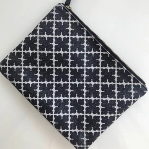  - En av By Malene Birgers ikoniska väskmodeller i det klassika svartvita färgställningen.  Man kan använda den som en necessär eller en liten kuvertväska. Den är begagnad och har spår av användning men är i brukbart skick. L: 22 cm. H: 16 cm