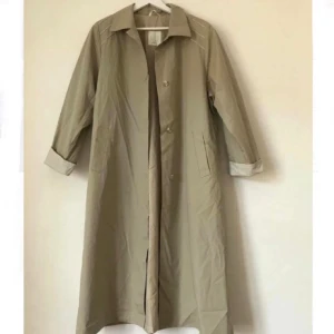  - Beige/grå tunn kappa. Prickigt innerfoder. Perfekt vårjacka! ✨🌸✨ Färgen är som en blandning av första och sista bilden. Storlek 42 men passar nog mindre storlekar också.   Möte i Stockholm eller skicka mot fraktkostnad! 🌿🌞🌱