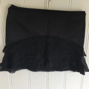  - Kort kjol från franska Kookaii i satin med överlappande volanger. Jätte fint skick ock kjol! Storlek 38