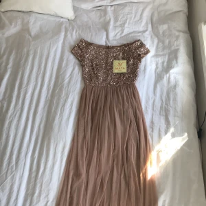  - En vacker och supersnygg balklänning, bröllopsklänning eller festklänning i en ljusrosa/rosé färg, storlek 34. Den är aldrig använd och prislappen sitter kvar, köptes för 1499kr via asos.com, men jag säljer den för endast 999kr + frakt 😊 Tar swish.