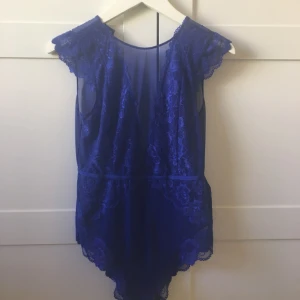  - Blå body i spets från H&M. Ej använd, lapp finns kvar. Nypris 249kr. Knappen i nacken saknas tyvärr. Djur finns i hemmet!