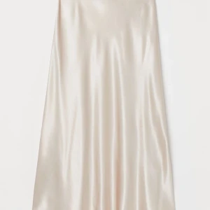 Rosa satinkjol - Säljer denna knälånga ljusrosa satinkjolen från H&M som använts max 3 gånger - därav nyskick. Verkligen superfin när man väl stryker den och hänger så fint! Strl 36 men är stretchig så passar säkert en storlek mindre/större! (Första bilden lånad från H&M, så ser kjolen ut när den är strykt och fin)