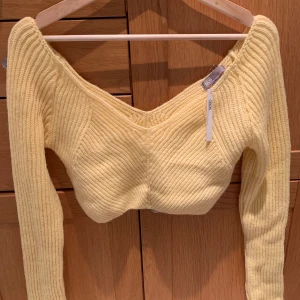 Grovstickad topp - Grovstickad kort tröja i gul. Aldrig använd med prislappen kvar i storlek 40. Nypris: 343kr