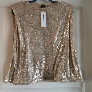 NY!! Paljett topp  - NY Paljett topp från Gina Tricot. Guldiga paljetter. Strl L. Lappen sitter kvar. Nypris 399:- perfekt topp till jul eller nyår 😍 köparen står för frakten och jag tar alltid +2:- för emballage 