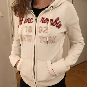 Abercrombie & Fitch huvtröja / hoodie - Abercrombie tröja i storlek M men känns snarare som en S. Sitter figursytt på kroppen. Köpt i New York på Abercrombie & Fitch. Mycket fint skick men har ett mini-ljusgult litet streck som typ inte syns. Eventuell frakt tillkommer.
