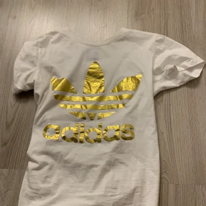 Adidas  - Adidas t-shirt med guld märke, storlek S använd en gång (pris kan diskuteras) 