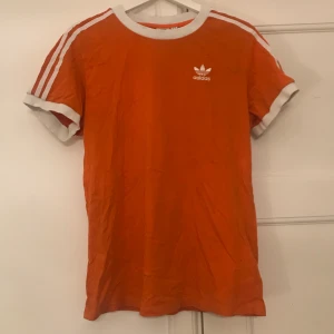 Orange adidas T-shirt  - Cool adidas T-shirt som tyvärr inte kommer till användning längre. Inga fläckar eller hål då tröjan inte kommit till användning särskilt mycket. Tröjan är i storlek s man.