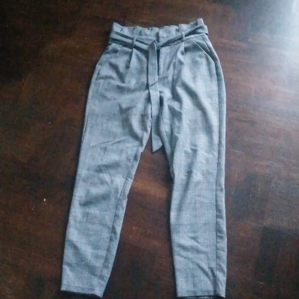 Snygg rutig byxa från Vero Moda. Veckad i byxlinningen samt matchande tygskärp. . Jeans & Byxor.