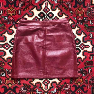  - Kjol i röd lack/konstläder.  Passform: tajt.  Köparen står för frakt, kan även mötas upp!