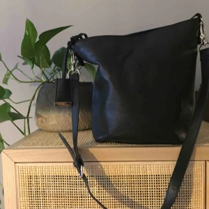  - Väska i utmärkt skick från Åhlens. Inget att anmärka på skicket. Långa axelbandet kan tas av. Lite bucketmodell