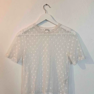  - Vit/transparent topp med prickar.