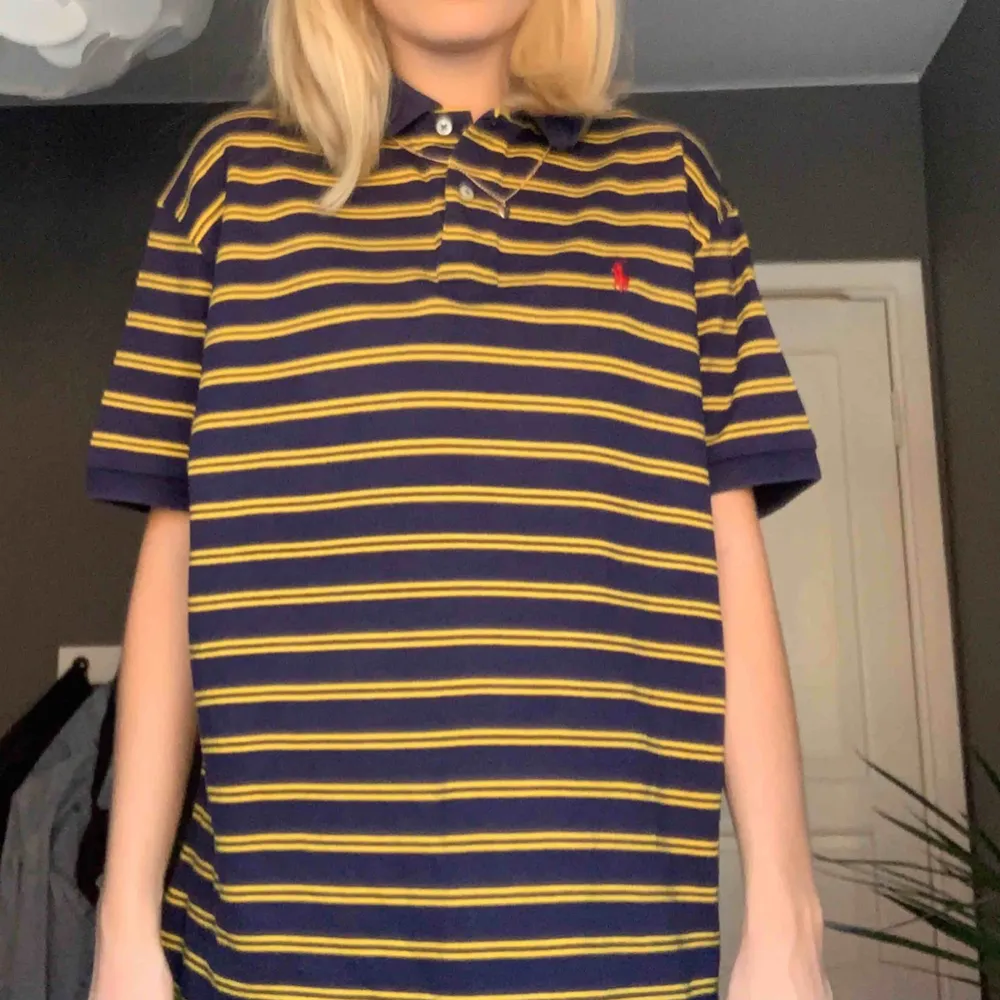 Mörkblå- och gul-randig piké från Ralph Lauren. Väldigt lång i modellen men är väldigt snygg att stoppa in eller klippa av!! . T-shirts.