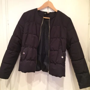  - Marinblå kort jacka.