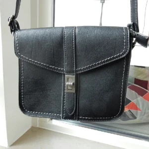  - Svart axelremsväska. Jag skulle gissa på att det är konstläder. Som ny! 