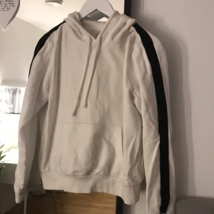 Hm hoodie  - Vit hoodie från hm med svarta sträck på armarna, knappt använd med lite nopprig vid armarna från tvätt
