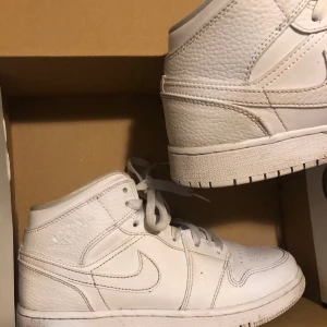 Nike Air Jordan 1 - Nike Air Jordan 1 (mid), vita i storlek 36,5. Liite smutsiga men går lätt att tvätta bort, annars är dom i bra skick och hela. 