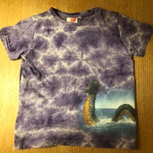 Baby tee  - Sååå cool lila baby-tee med tyo ett sjöodjur på. Den är som tiedye. Frakt tillkommer :) 