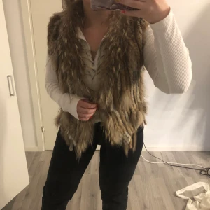 Äkta pälsväst  - En äkta pälsväst köpt på Holmlunds i uppsala för 2000kr. Den är lite sliten på ena sidan men det är verkligen inget man tänker på!