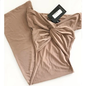 Beige klänning omlott offshoulder XS - Färg: beige.  Strl: EUR 32/ UK 4 / US 0. Skitsnygg klänning i stretch.  Figurnära & skönt material. Ger fina former! Aldrig använd. Obs. LAPPAR KVAR!  Kommer ej till användning & stor garderobsrensning pågår! Betalning via swish. Frakt tillkommer.