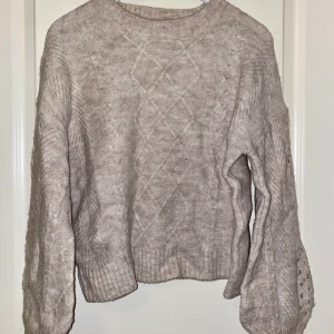 Beige oversize tjocktröja - En beige tröja med lite tjockare tyg. Mönster med hål på ärmarna. Perfekt nu inför vintern. Använd 1 gång. ☺️