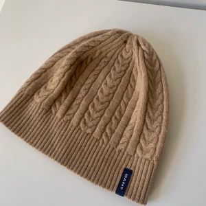 GANT mössa - Kabelstickad ullmössa från Gant i kamelbeige. Jättefint skick! Nypris ca 600kr 