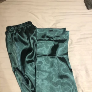 Satin pyjamas byxor - Säljer dessa super fina satin pyjamas byxor i en fin mörk grön färg! Helt oanvända då jag är vädligt lång (174) o de var för korta🥰ny pris 250kr säljer för 150kr har kvar prislapp o kvitto🥰