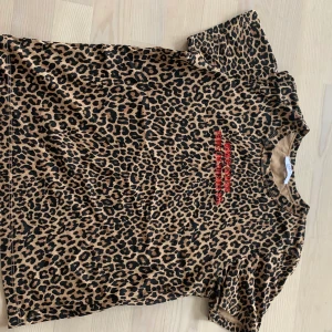 Mönstrad T-shirt  - Leopardmönstrad T-shirt från ZARA med röd text på bröstet. Aldrig använd, i nyskick 🤗 lös passform men lite figursydd.
