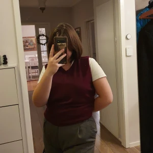 Vinröd väst - Vinröd stickad väst från Dressman. Sparsamt använd och i relativt bra skick.