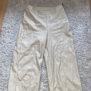 Beiga läderbyxor ifrån Gina Tricot i strl S - Beiga läderbyxor i strl S ifrån Gina Tricot. De har dragkedja på sidan och är köpta i somras