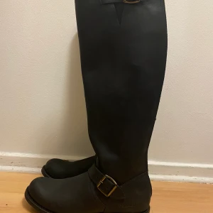 Primeboots,  - Knähöga stövlar med guldiga detaljer från Primeboots i storlek 38. Stövlarna är nyskick. Kvitto, skokartong och dustbag finns. 