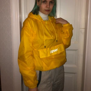 Gul vindjacka - En gul vindjacka från carlings med reflex på magen. Den är luftig samtidigt som den skyddar mot vinden. Perfekt att ha på sommaren. Frakten är inkluderad i priset. Den är köpt för 400 kr från början och endast använd 1 gång tyvärr.