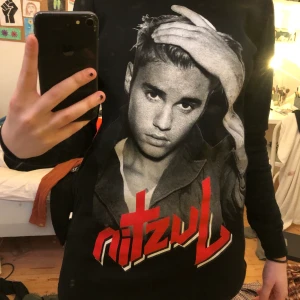 Justin Bieber - En tröja med Justin Bieber på. En bild på han på framsidan och sen står det ”Justin Bieber” på båda armarna. Den är ganska lång och är lite fluffig på insidan 
