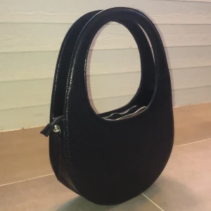 Svart väska - Jätte cool väska i ormskinns mönster. Från NA-KD. Använd väldigt få gånger, nyskick. 