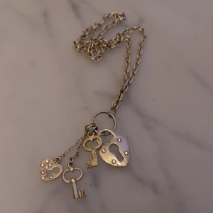 Silvrigt hjärt och nyckelhalsband  - Säljer mitt fina nyckelhalsband pga att jag inte använder de längre. Väldigt fint och vardagligt halsband. Frakt ingår i priset. 