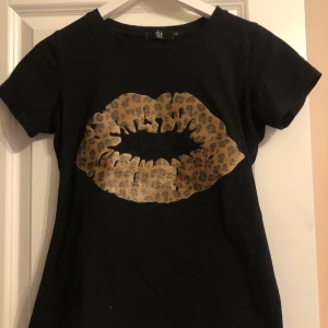 T-shirt  - Super fin t-shirt med ett guld pussmärke på, sitter jätte bra och fint skick då den bara är använd ett fåtal gånger. Köparen står för frakten och priset kan diskuteras 