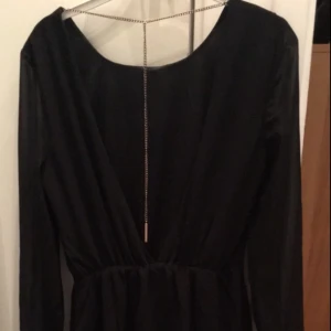  - Fina vart klänning med djup v-ringning i ryggen och med guldkedja 