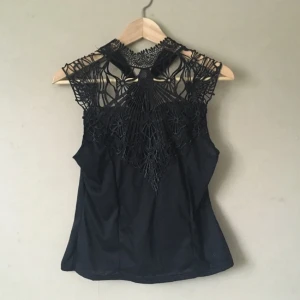  - Svart top med mönstrat bröst och ett band att knyta runt halsen. Den gör sig inte rättvisa på galgen, om du är intresserad jag kan visa hur den ser ut på! 

Frakt tillkommer, tar swish!