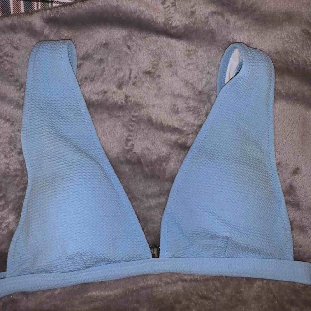 Blå bikiniöverdel från zaful. Kommer inte till användning längre. Fint refflat material. Frakt ingår i priset 💞   (Den ser lite fläckig ut men de är bara blixten, den är felfri). Övrigt.