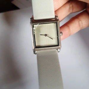 Silvrig grå klocka - En silvrig klocka med grått armband. Nypris 200ish. Använd ganska mycket o en liten spricka, därav priset. Batteriet går enkelt att byta själv eller hos en urmakare. 🌼