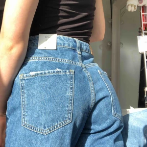  - Super fina mom jeans från Gina Tricot i modellen Siri. Säljer då jag inte han lämna tillbaka de då de var förstora för mig, men de är aldrig använda o i toppen skick!! Möts upp i Stockholm och fraktar!❤️💕🥰💕medela för bild på hela jeansen oså💕