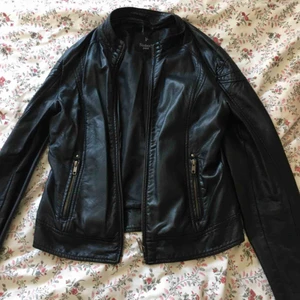 Skinnjacka - Jacka i skinnimmitation. Köptes för ca 8 år sedan och användes endast några fåtal gånger. Säljes då den inte kommer till användning. •Köparen står för frakten!