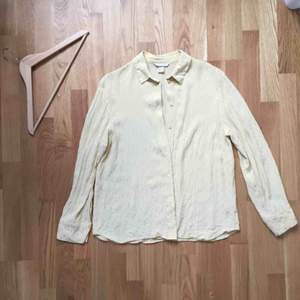 Ljusgul skjorta från H&M. Blanka prickar i tyget. Hel och ren, men kanske skulle må bra av att strykas ordentligt. 