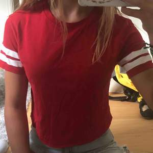Röd t-Shirt med vita ränder, passar även st S, nästan helt oanvänd, frakt tillkommer eller mötas i Stockholmsområdet 