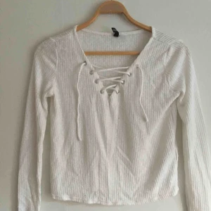  - Vit långärmad tröja men snörning fram,, tunn och skön att ha på en sommarkväll. Köparen betalar frakt,, kan mötas upp i Stockholm 