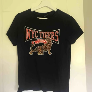  - Svart t-shirt med tryck från Gina Tricot.