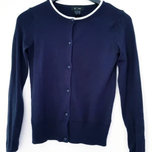  - Jättefin kofta i navy/mörkblått med vita dekorativa kontraster i halsingning. Knappar i mörkblått. Använd ett fåtal tillfällen, varför den är i fint skick. Säljes p g a utrensning. 