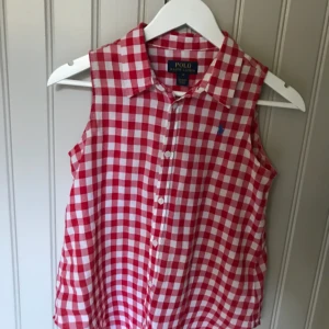  - Blus från Ralph Lauren. Kan knytas fram. Väldigt fint skick! Barn storlek 14, kan även passa XS. 