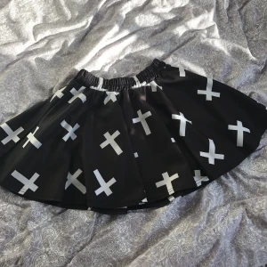  - Svart Kjol med kors. Använd 1-2 gånger så i bra skick. Vid frakt är det köparen som står för frakten