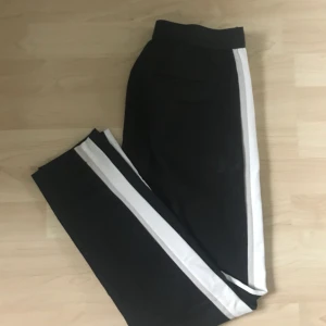  - Svarta kostymbyxor med vit och beige rand på sidan från zara i storlek S. Sitter tight och har bra passform. Köparen står för frakten 