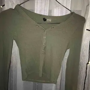 Militär grön långärmad tröja med knappar. Lite croppad. Använt typ 2/3 gånger.